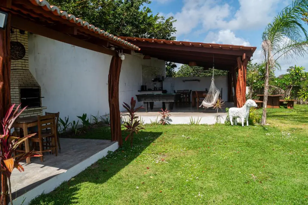 Área de churrasco com rede de descanso e mesa de sinuca